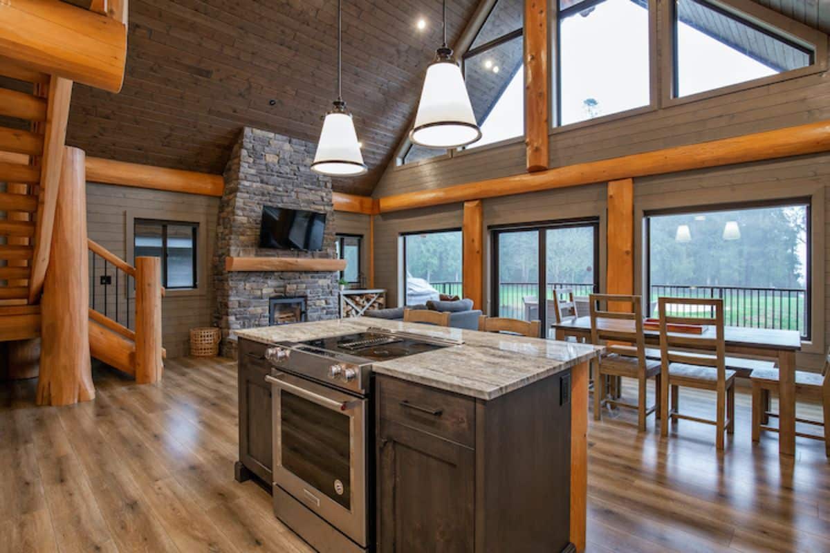 gray wood cabinets under island with stainless steel stove in center