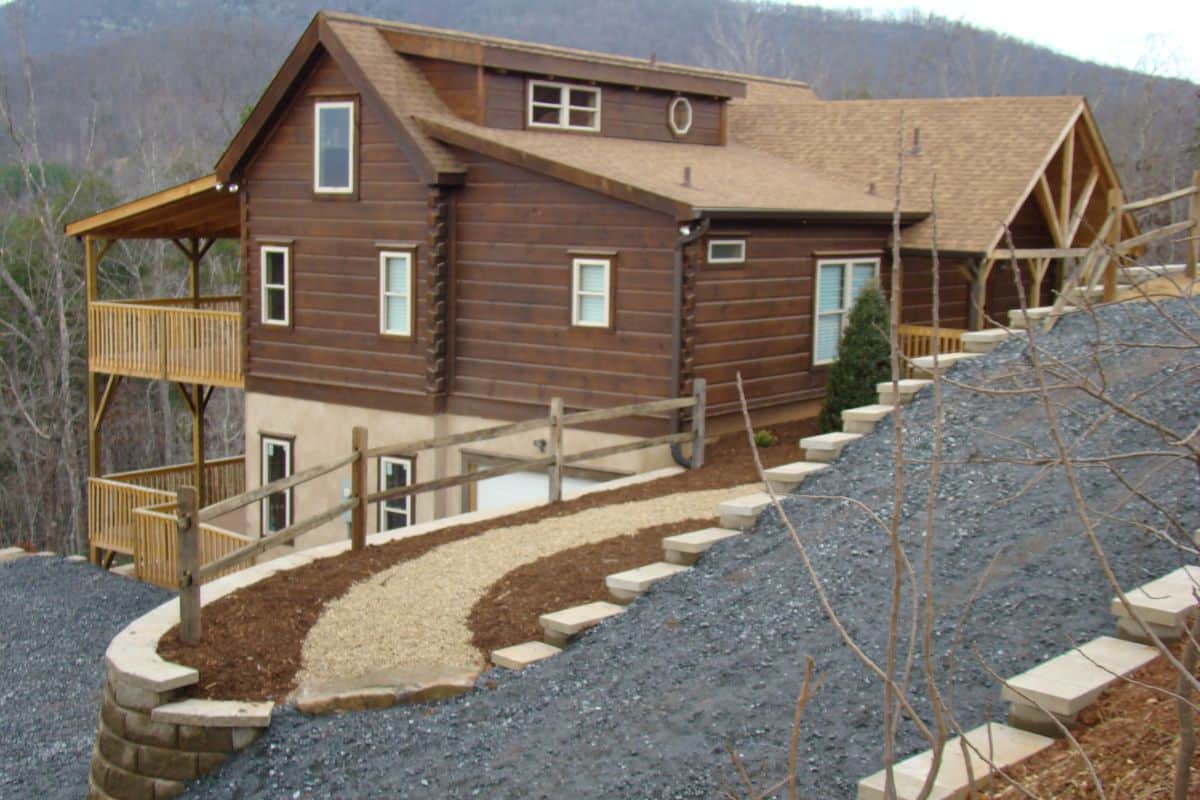dark wood stain on cabin on hill with stone walkway