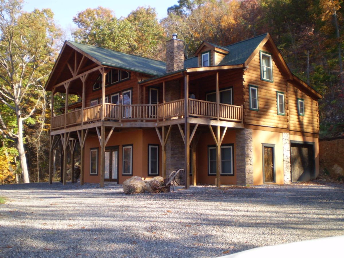 back walkout basement on two story cabin against hill