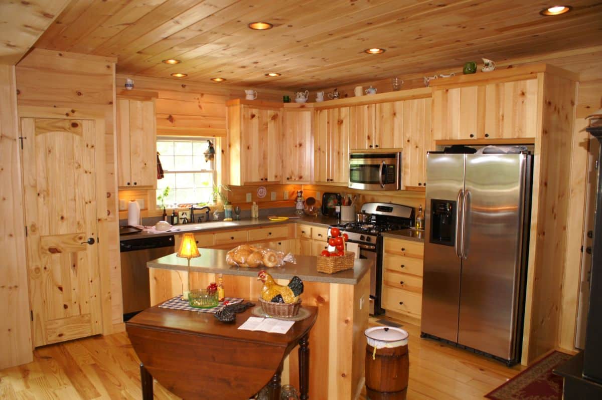 light wood kitchen with island and drop down table with stainless steel appliances