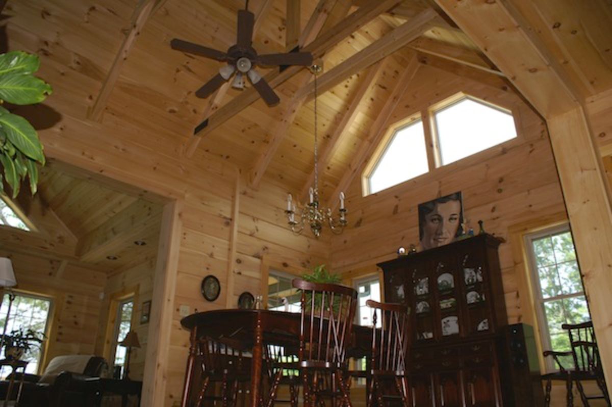 ceiling fan above round dining table next to dark wood hutch