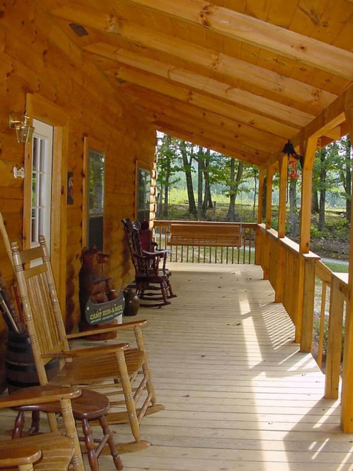 covered porch with rocking chairs beside white door