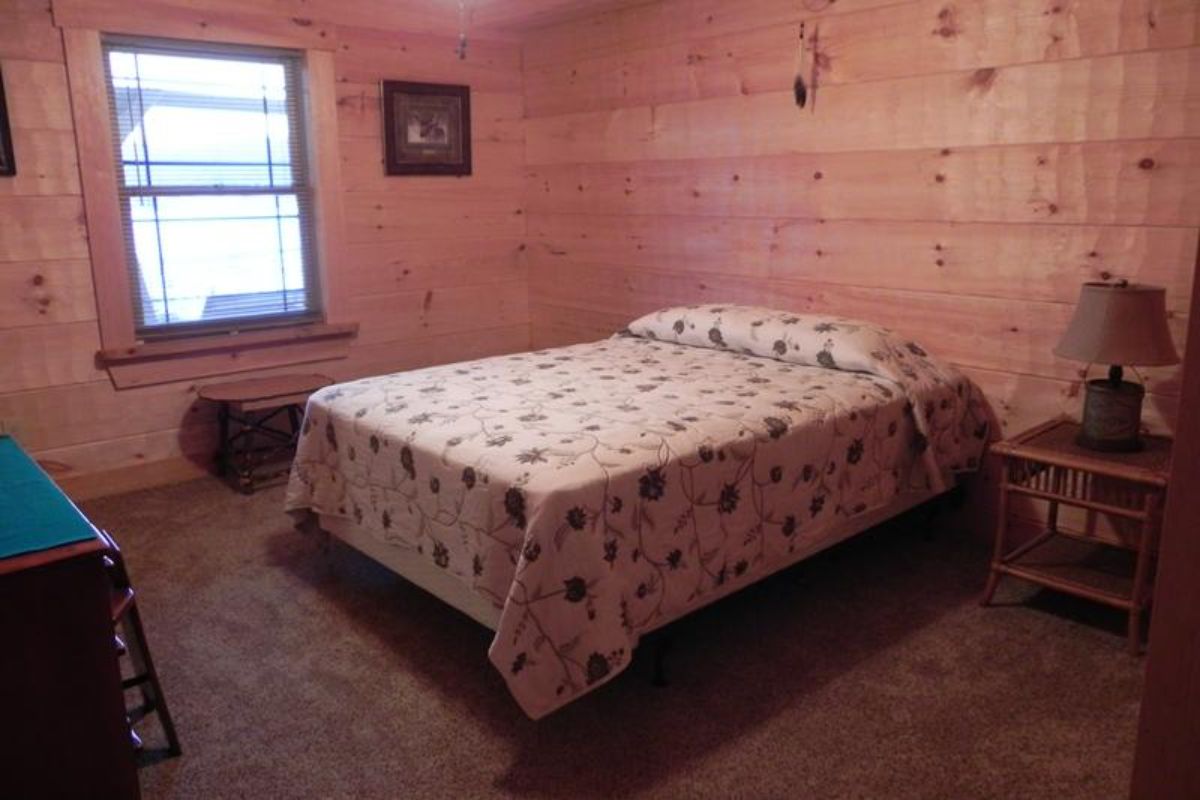 bed against light wood cabin wall