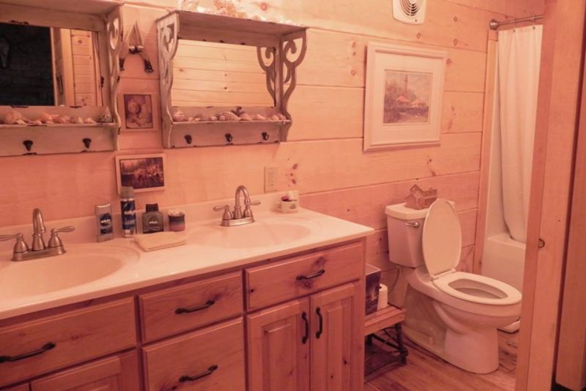 light wood cabinets with white countertops next to white toilet in bathroom