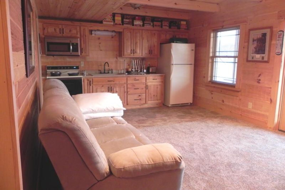 basement kitchenette with light brown sofa on left wall