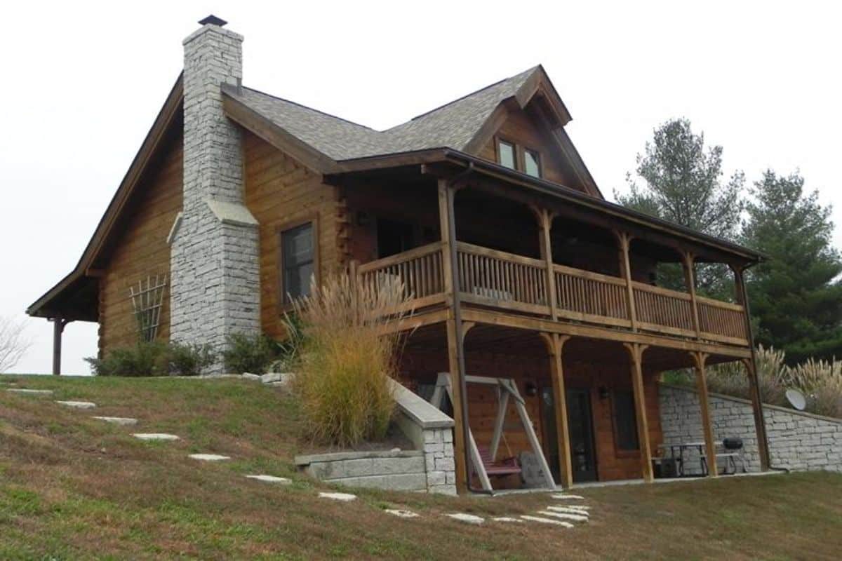 back of log cabin showing covered deck and walkout basement