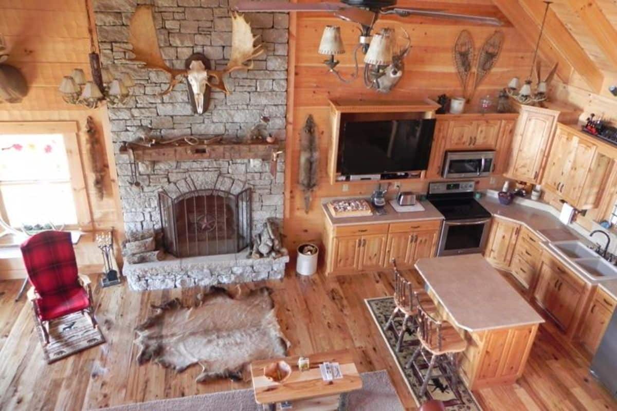 view from loft looking down into cabin living area with fireplace on back wall