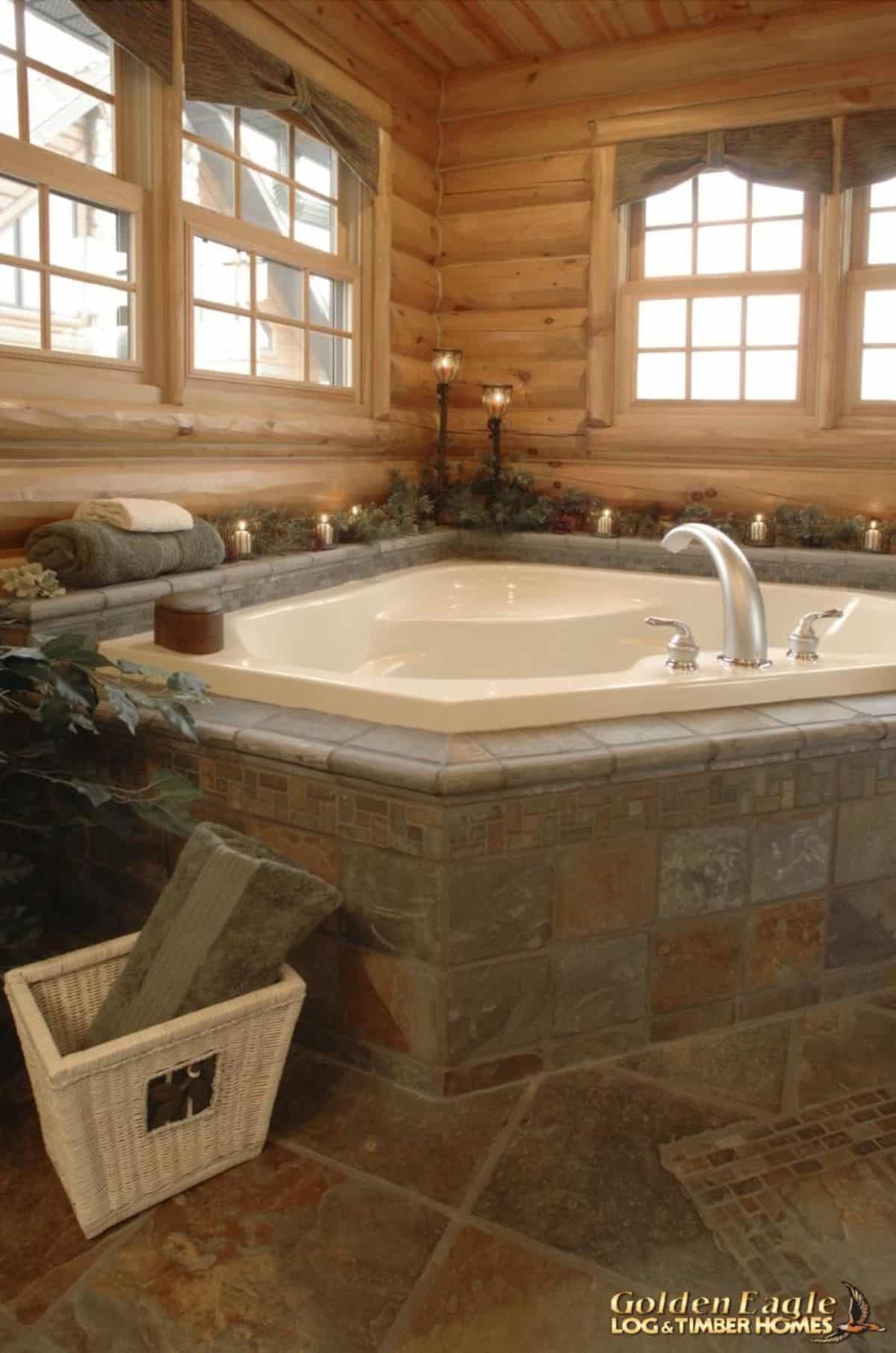 gray tile around white soaking tub in corner of bathroom