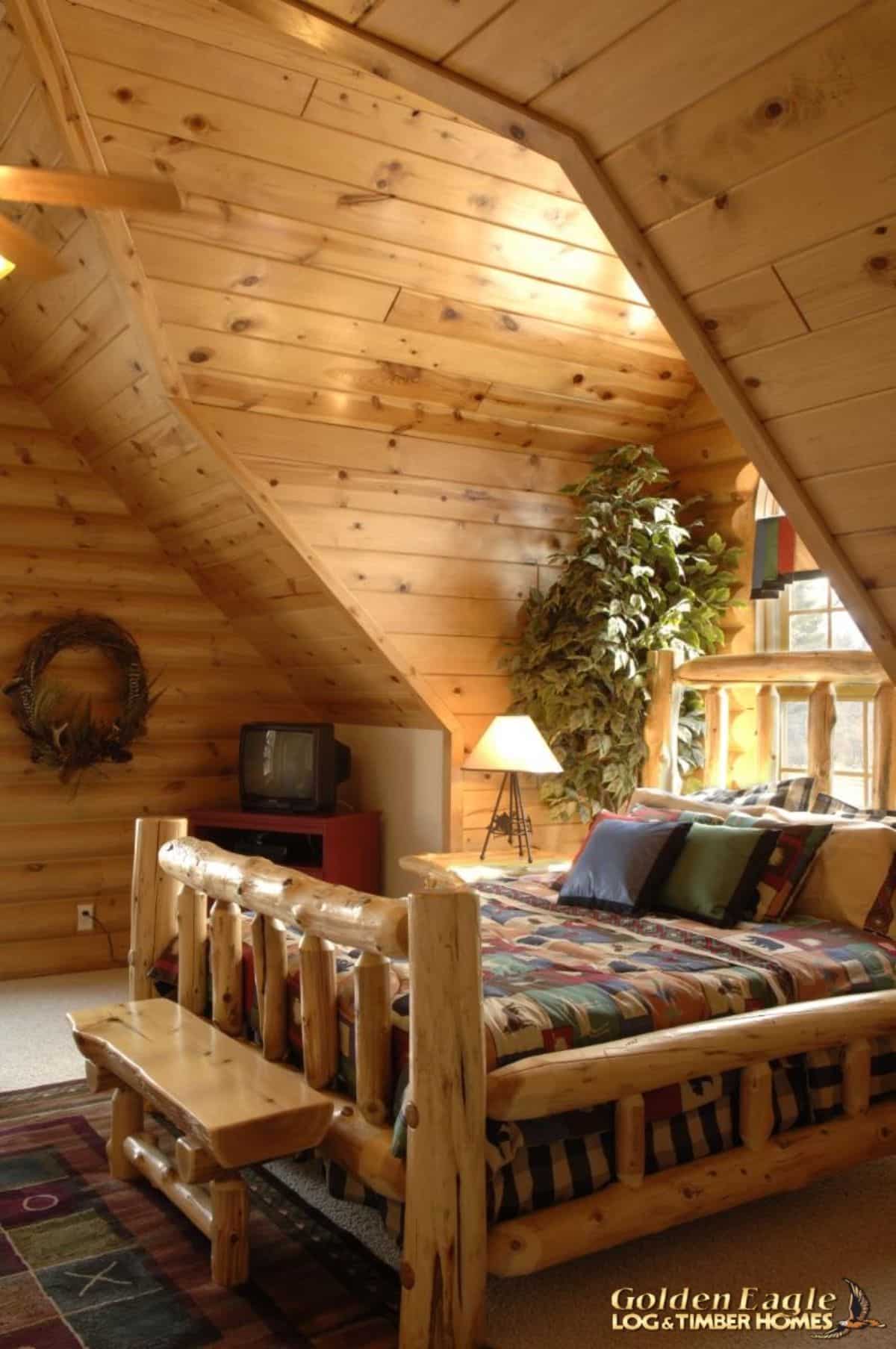wood bed frame under dormer window in cabin