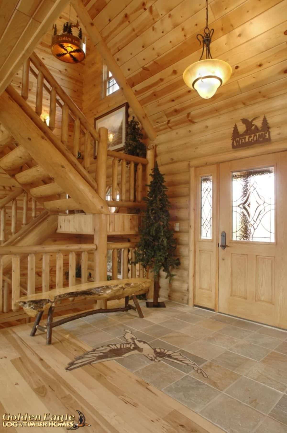 front entry of log cabin with tree inside door