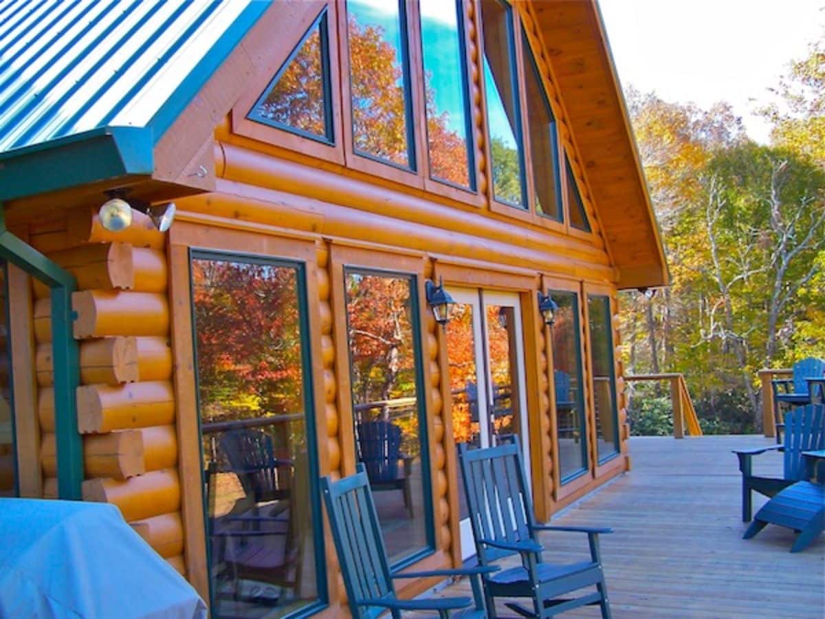 deck against wall of windows with green rocking chairs by windows