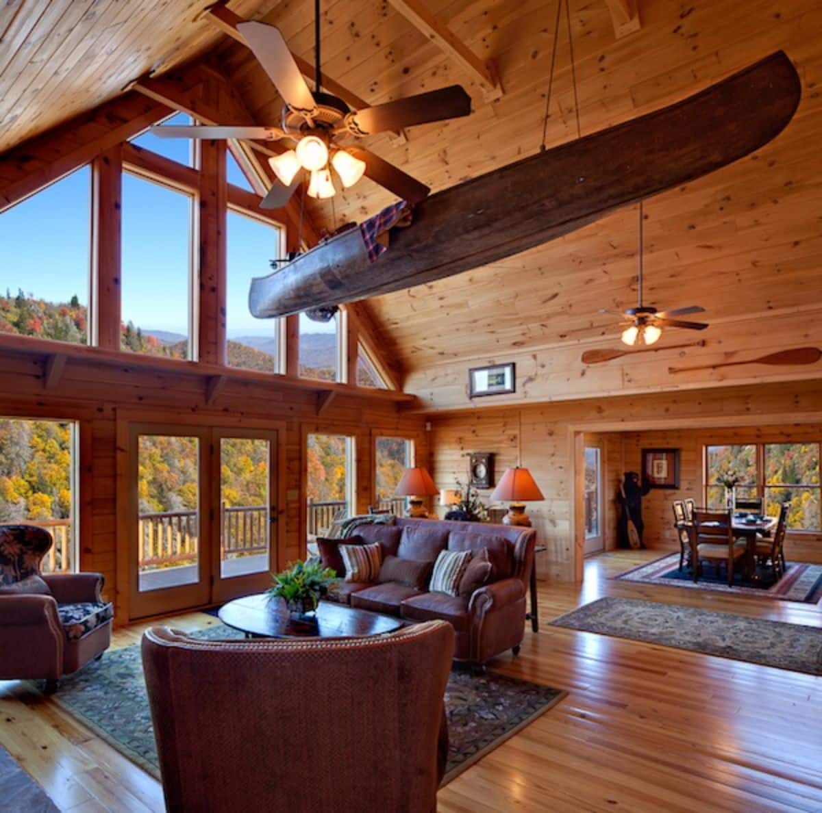 sofas and chais on rug in living area with boat hanging above space