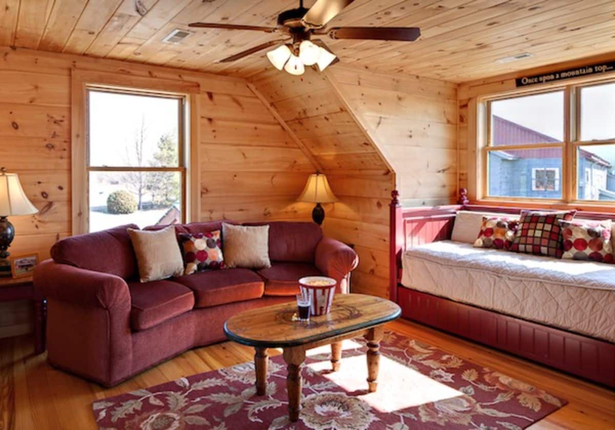 maroon sofa in loft with windows on both sides