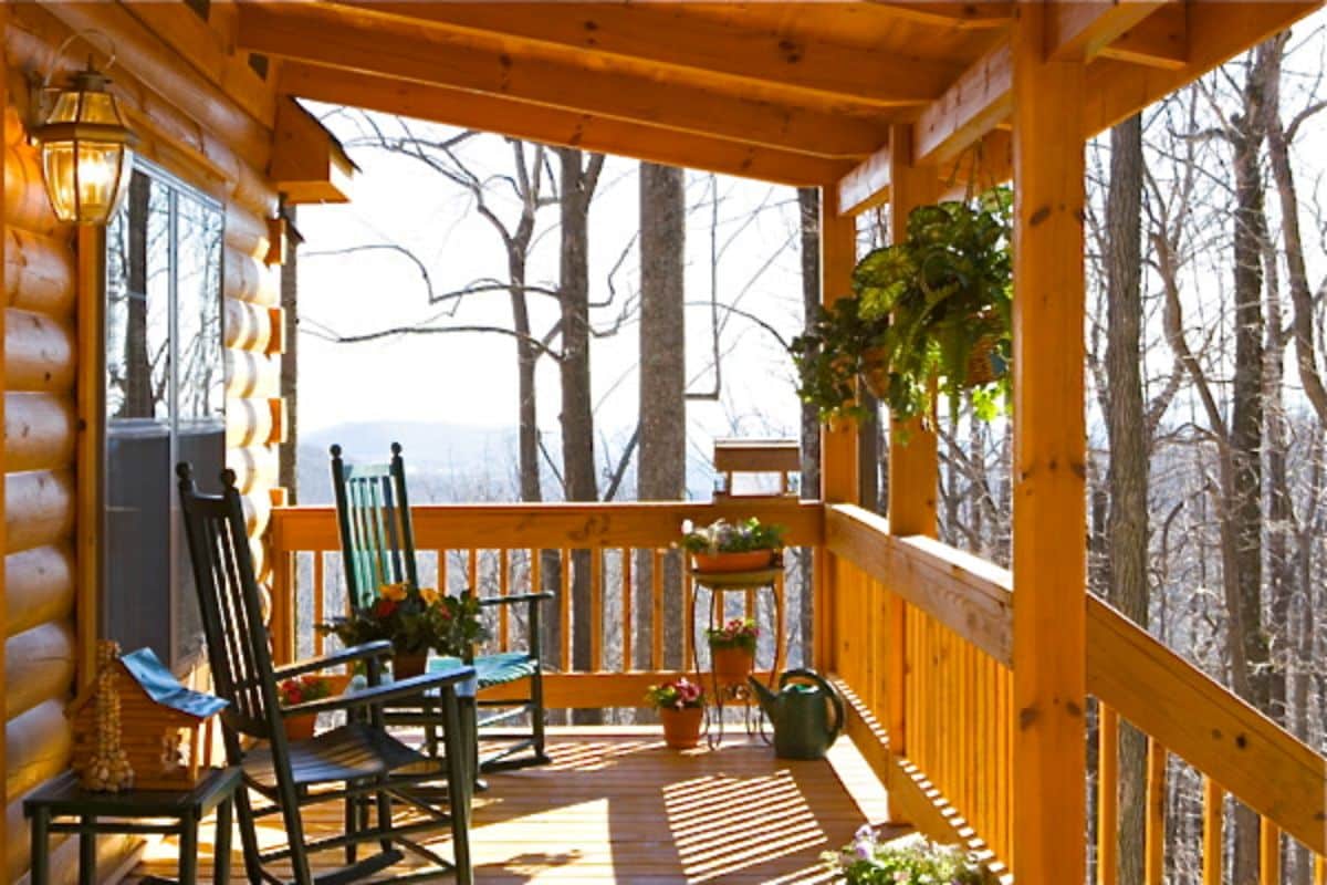 rocking chairs under roof of porch on cabin