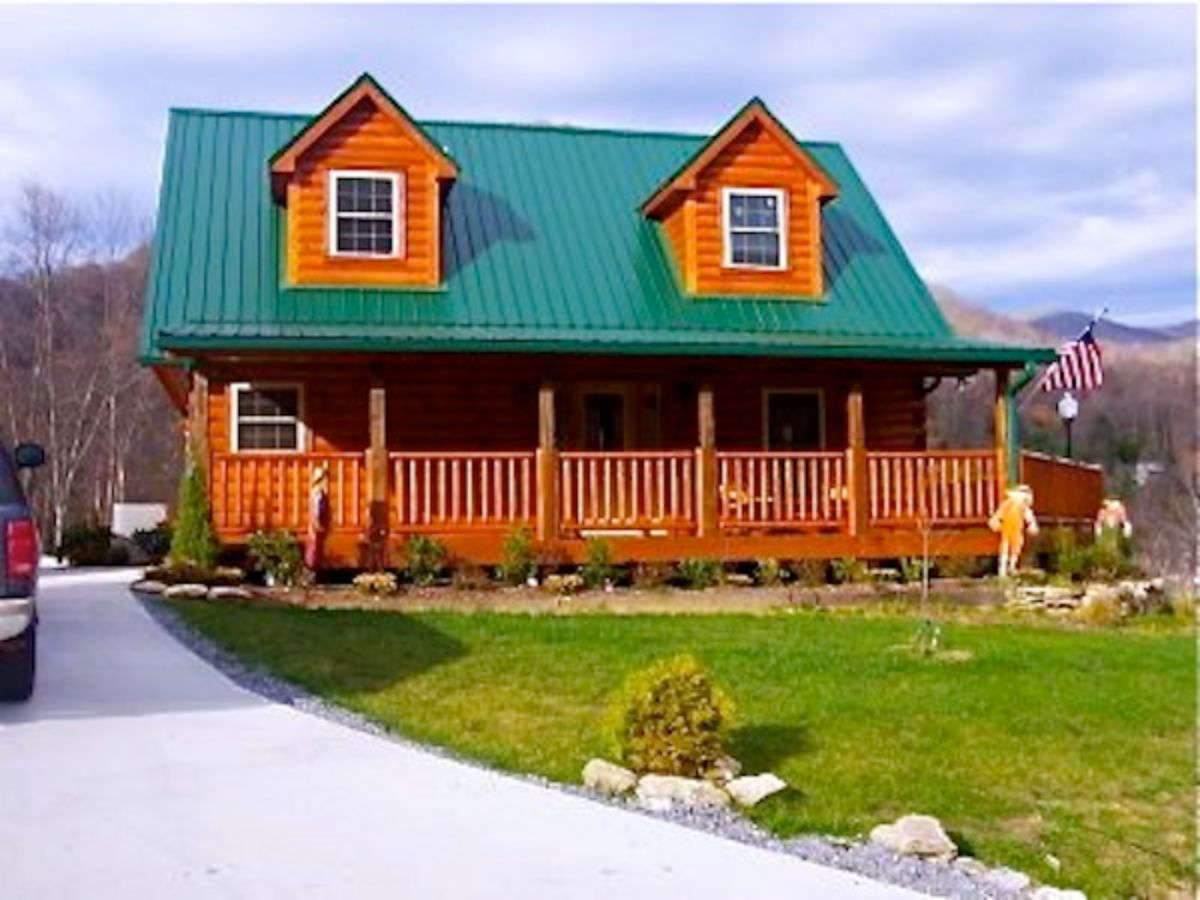 concrete drive leading to cabin with green roof