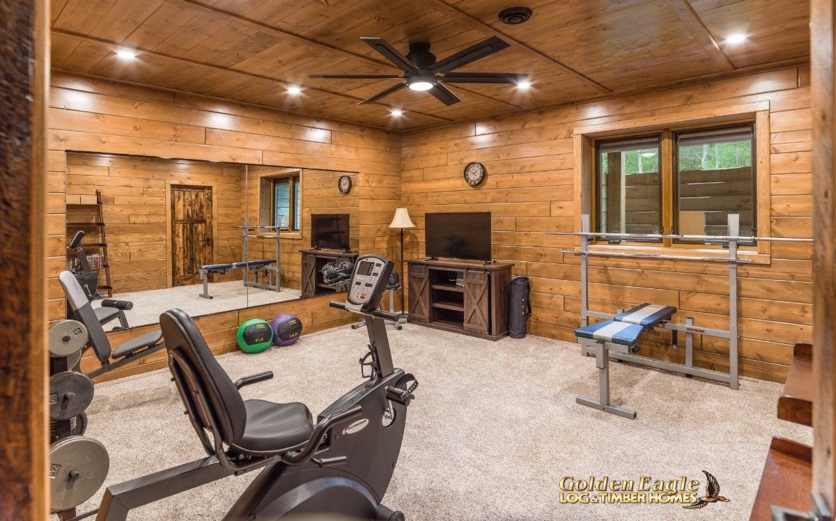 home gym in basement with weight bench on back wall