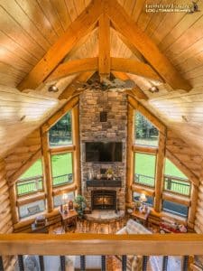 view from loft into great room with chimney and fireplace in center of space