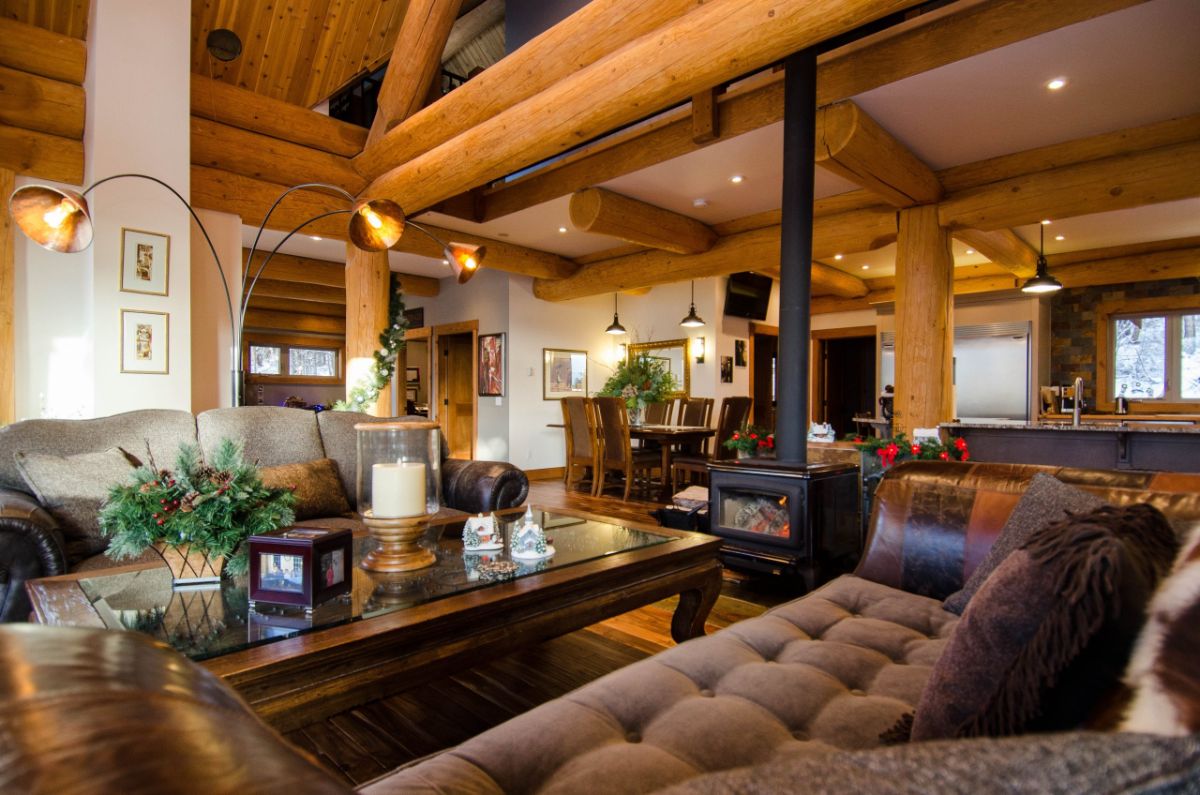 view into kitchen from living room across brown sofa with wood stove in background