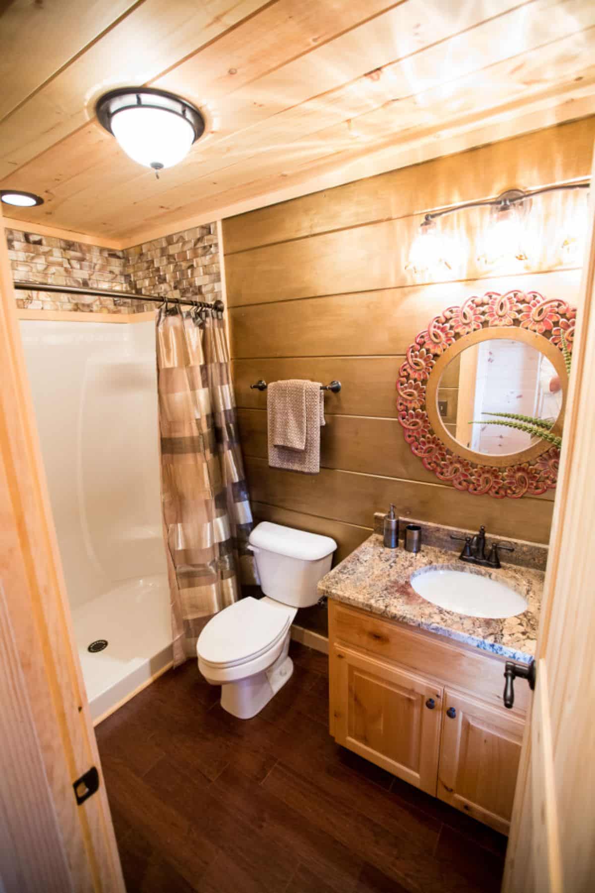 small bathroom with wood shiplap walls beside combination bathtub and shower