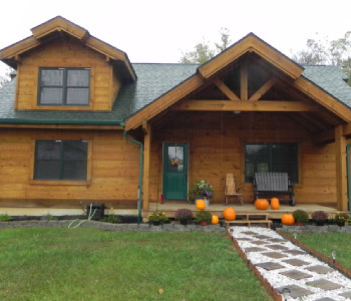 fronto f cabin with small porch and stone walkway with pumpkins on porch