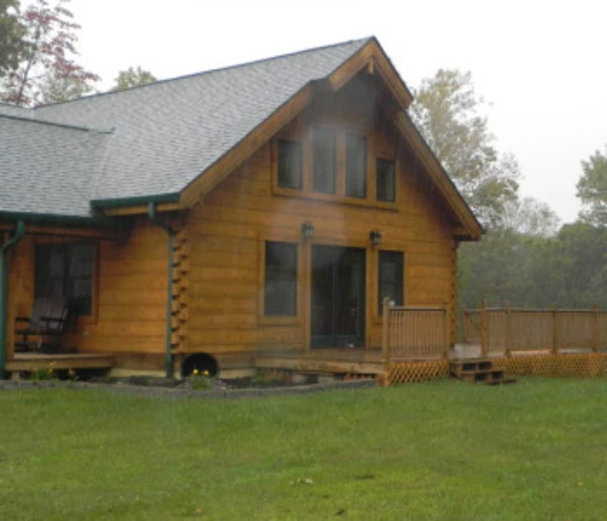 side of log cabin with small low porch and sliding door