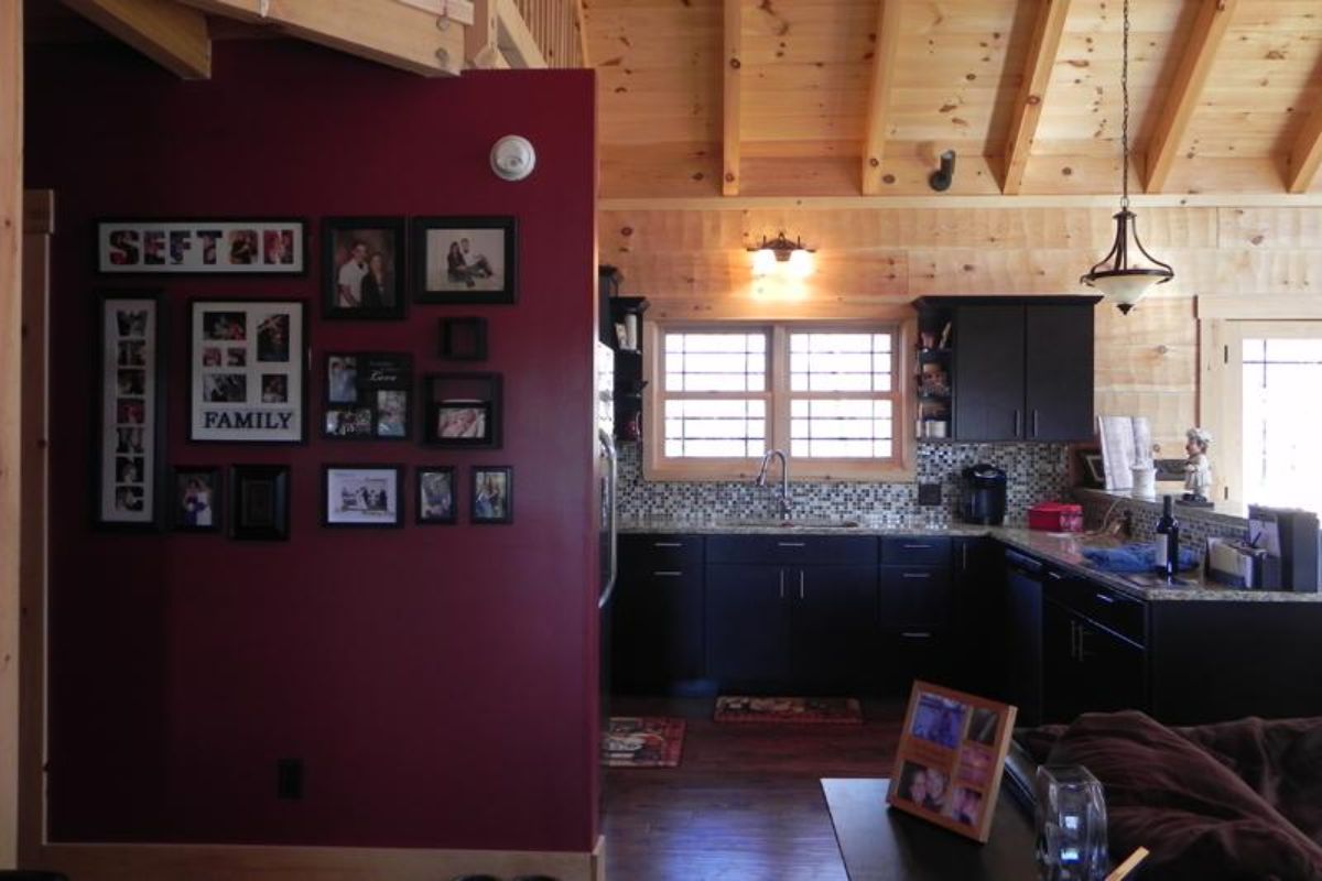 dark red wall on edge of kitchen with black cabinets