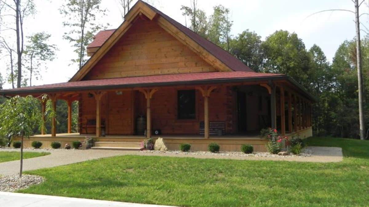 side porch on log cabin with light wood floors and roof covering porch
