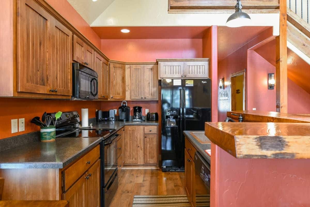 black refrigerator on end of kitchen