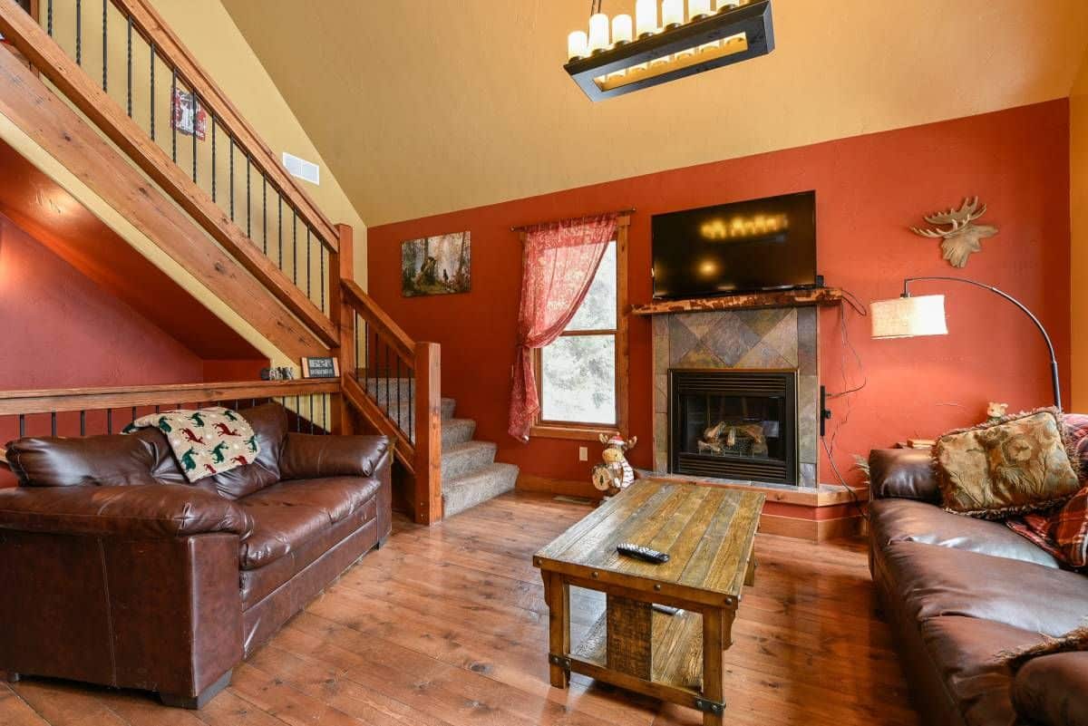 brown leather sofa on left with coffee table in center and fireplace on background wall