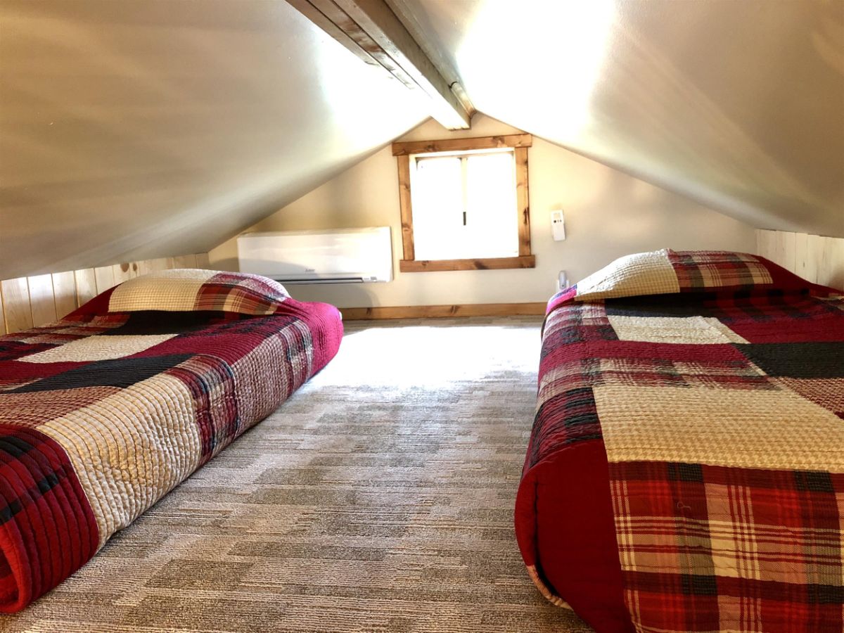 two beds in loft with red white and black flannel bedding
