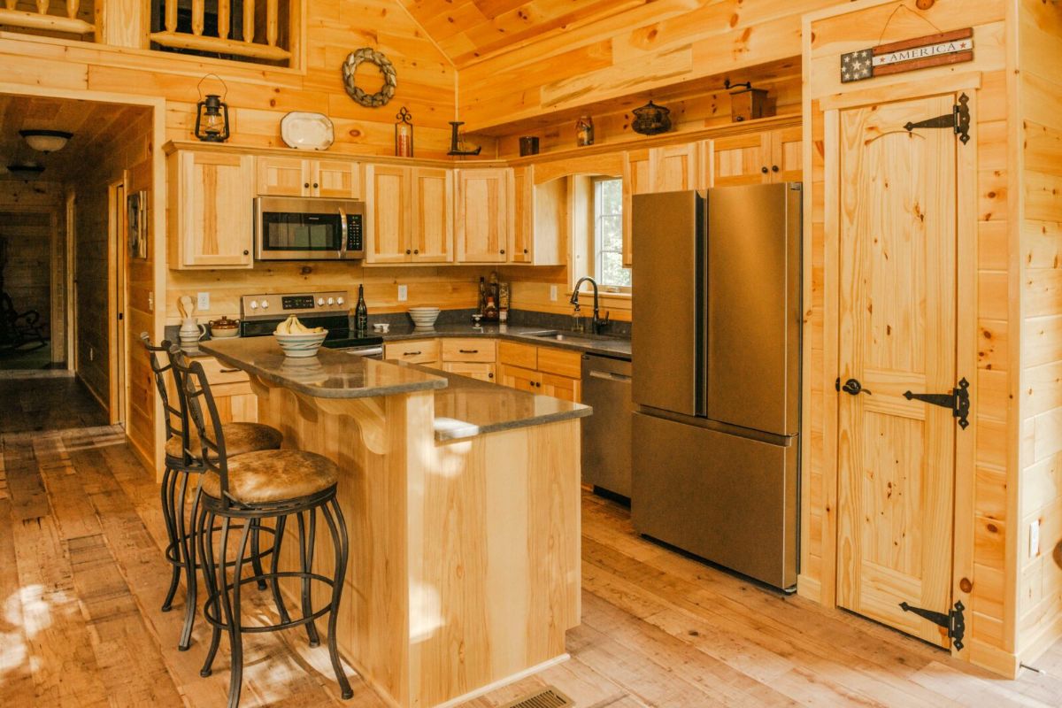 stainless steel refrigerator in kitchen with light wood island