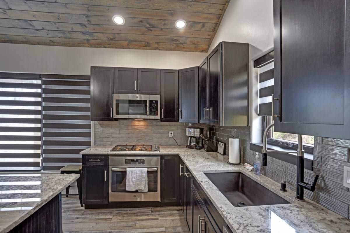 stainless steel oven against wall between gray cabinets of kitchen