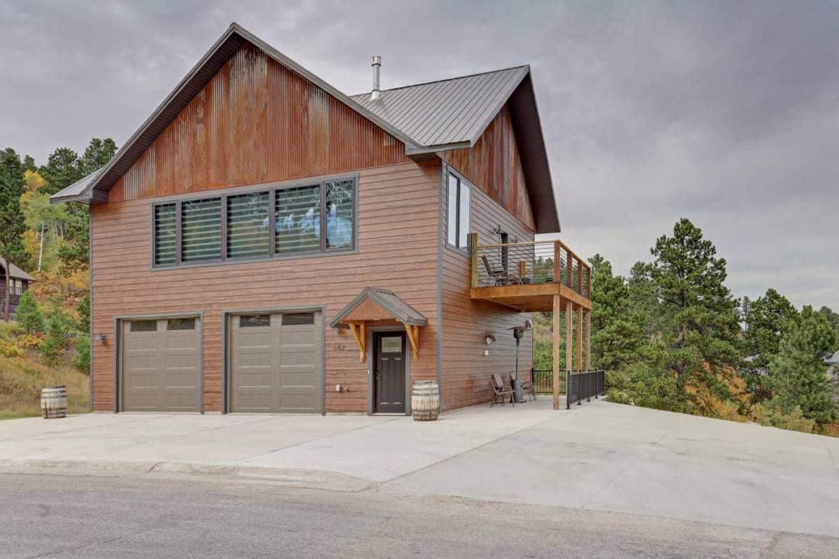 side of two story log cabin with garage doors on both sides