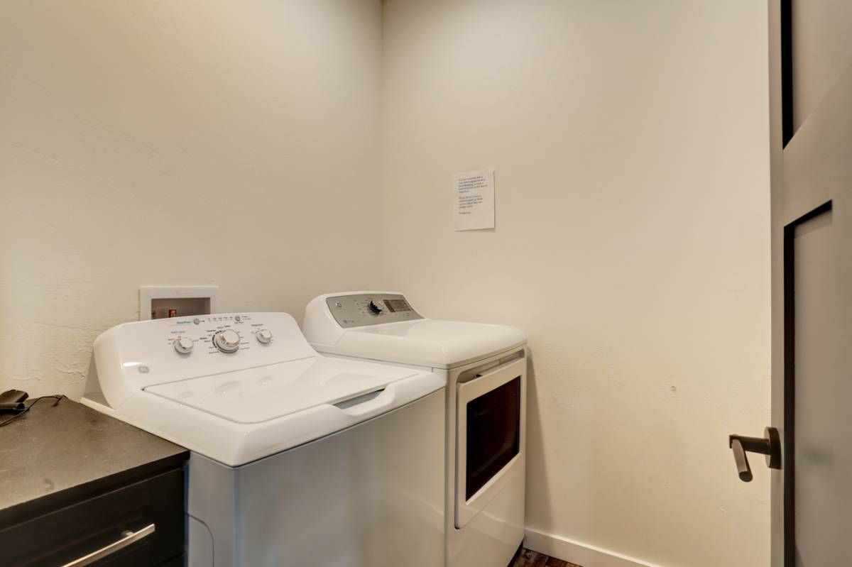 white washer and dryer against white wall of laundry room