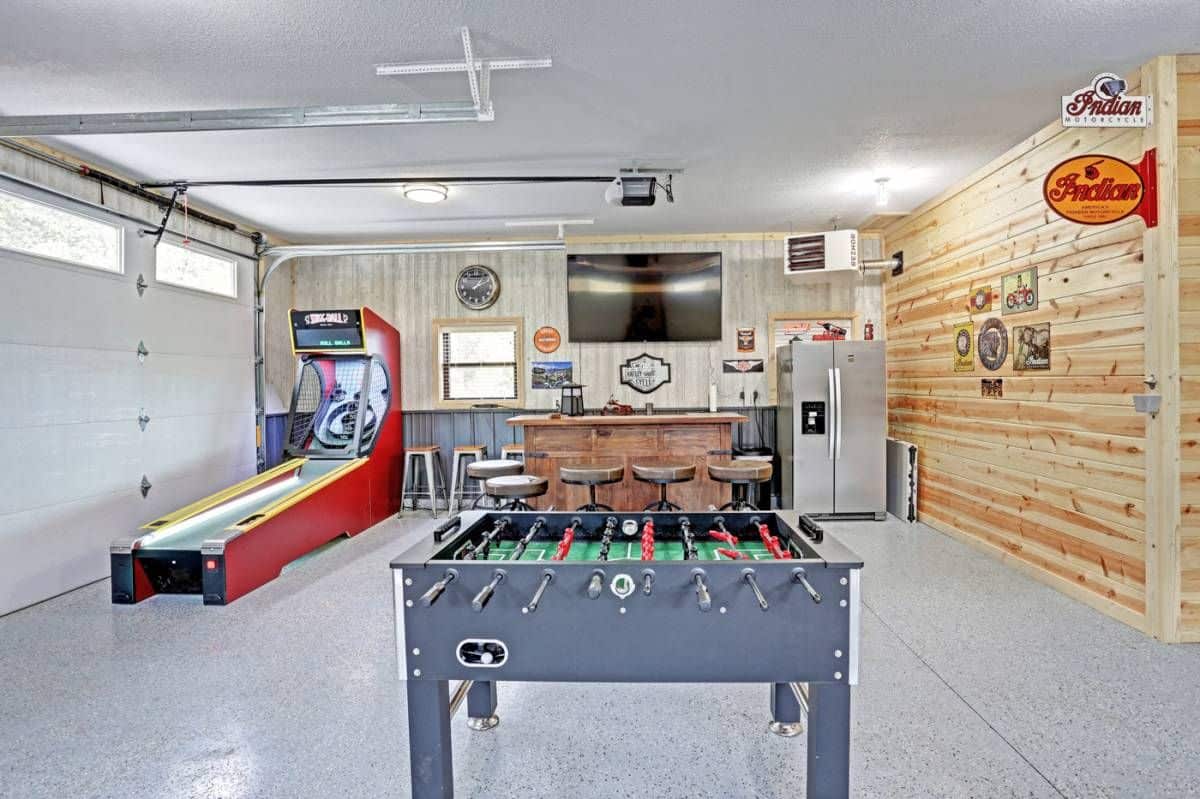 foosball table in foreground with tv and bar in background