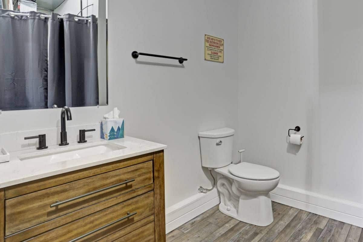 white walls behind toilet net to wood cabinet vanity