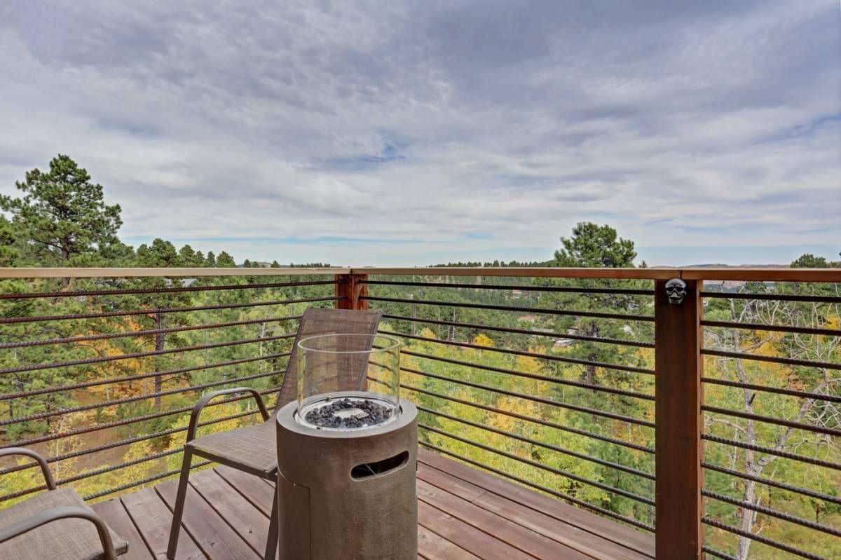 view over deck railing to tree lined property