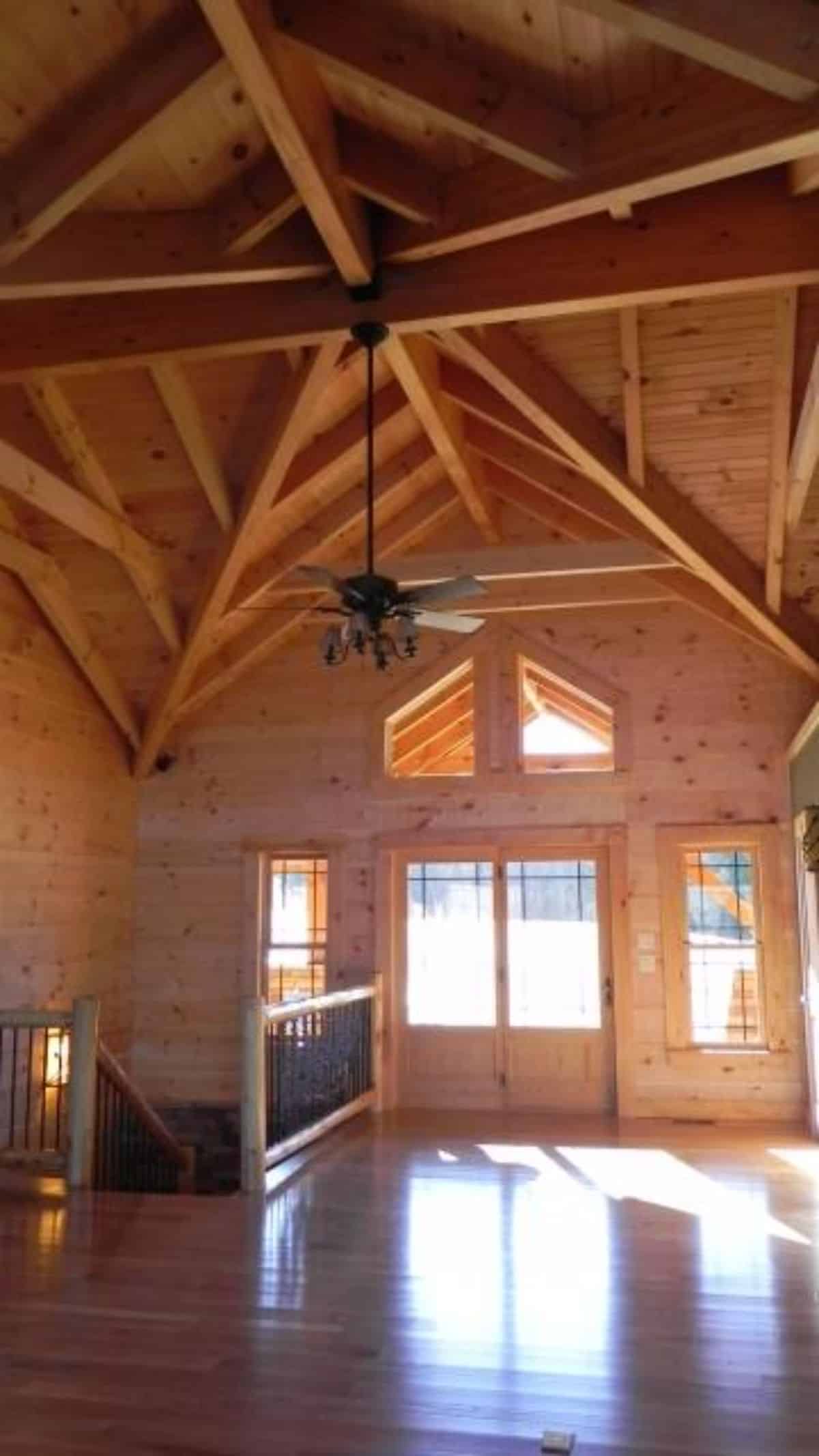 open entrance of log cabin with black ceiling fan hanging from ceiling