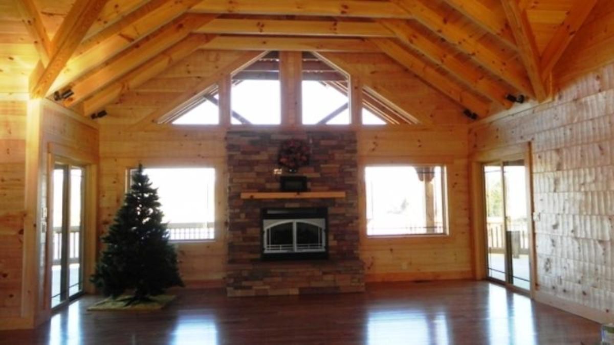 fireplace against wall with windows on both sides and christmas tree on left