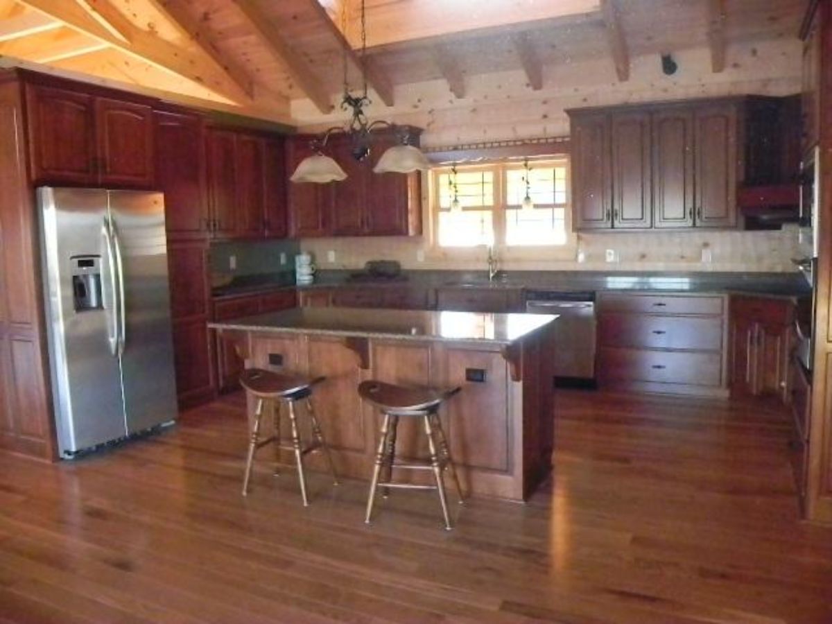 view into kitchen with wood stools under island bar