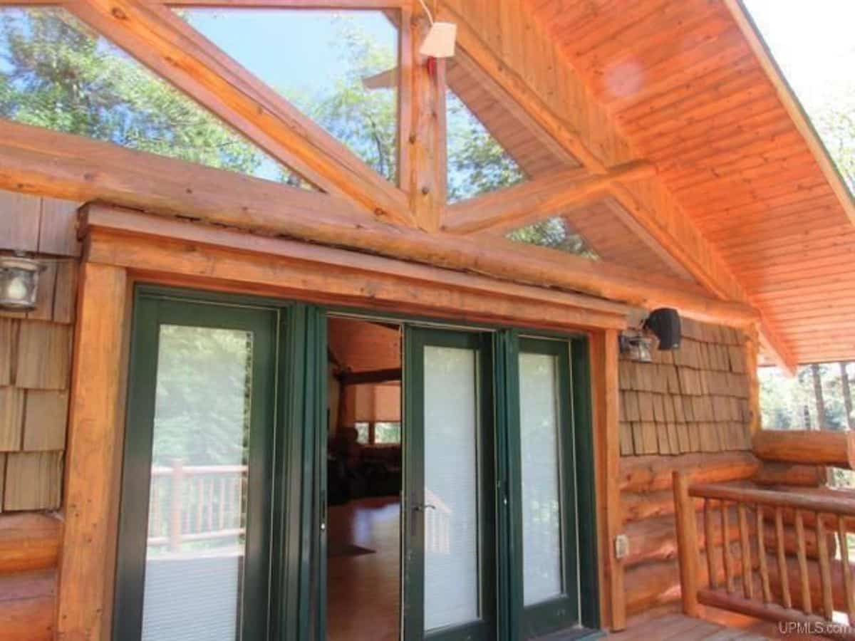 green doors leading off porch into cabin