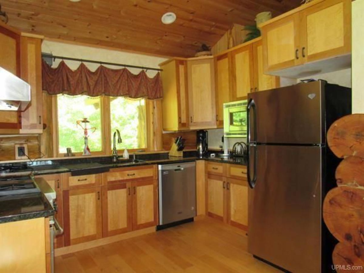 light wood cabinets and stainless steel appliances in kitchen of cabin