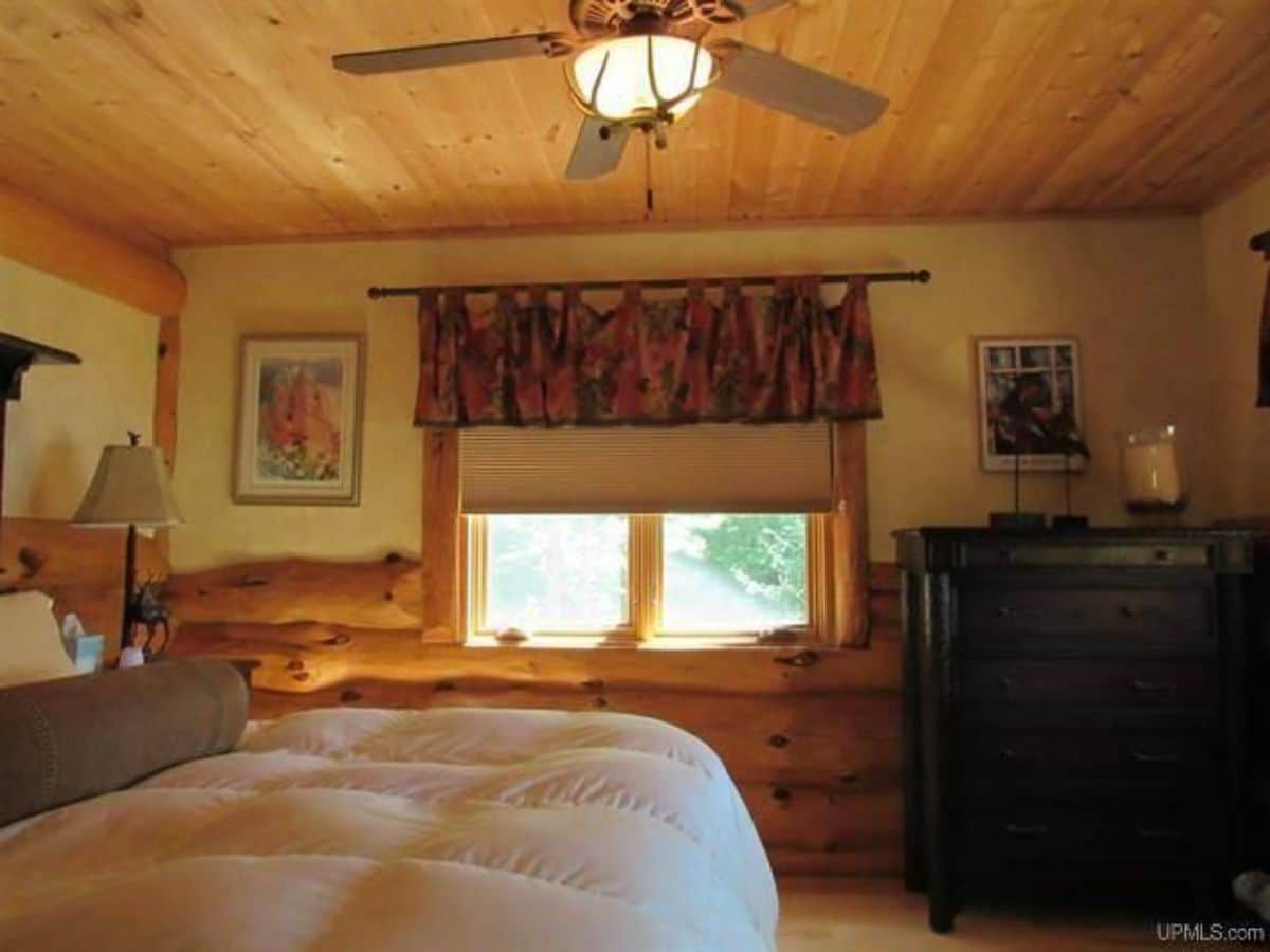 white bedding with black dresser in corner