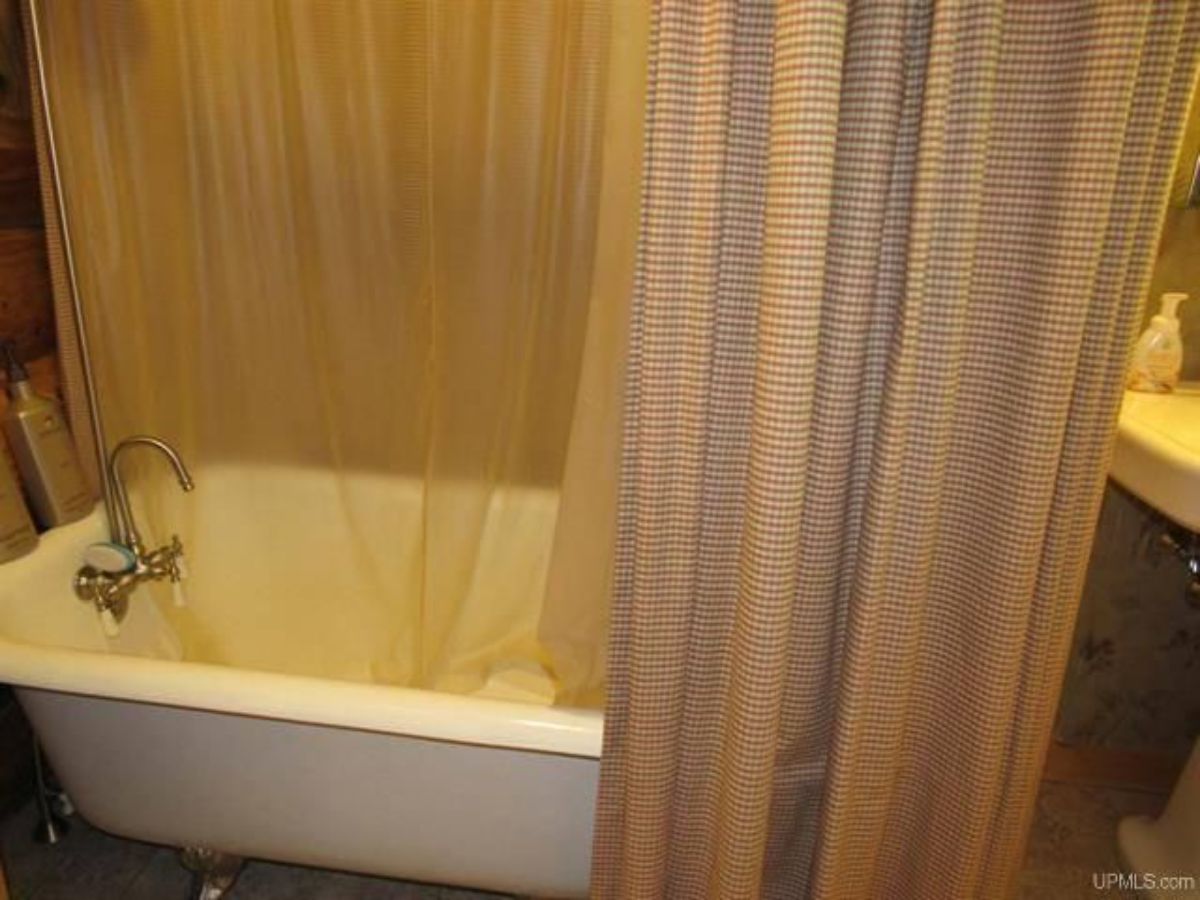 clawfoot bathtub with shower curtain around it