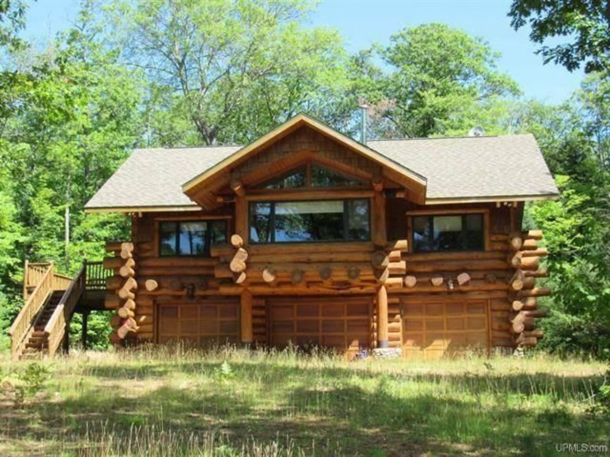 back of log cabin with great room windows in center