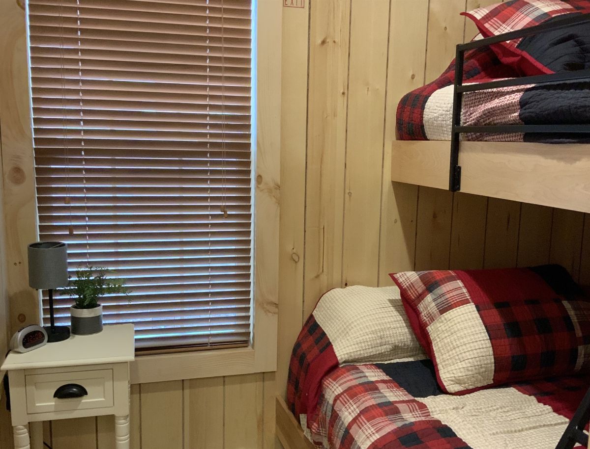 window beside bunk beds with red and white bedding