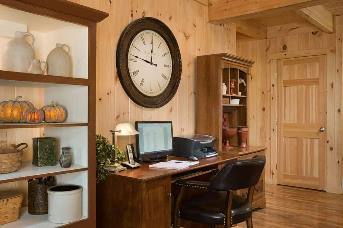 desk with monitor and black chair between two curio cabinets