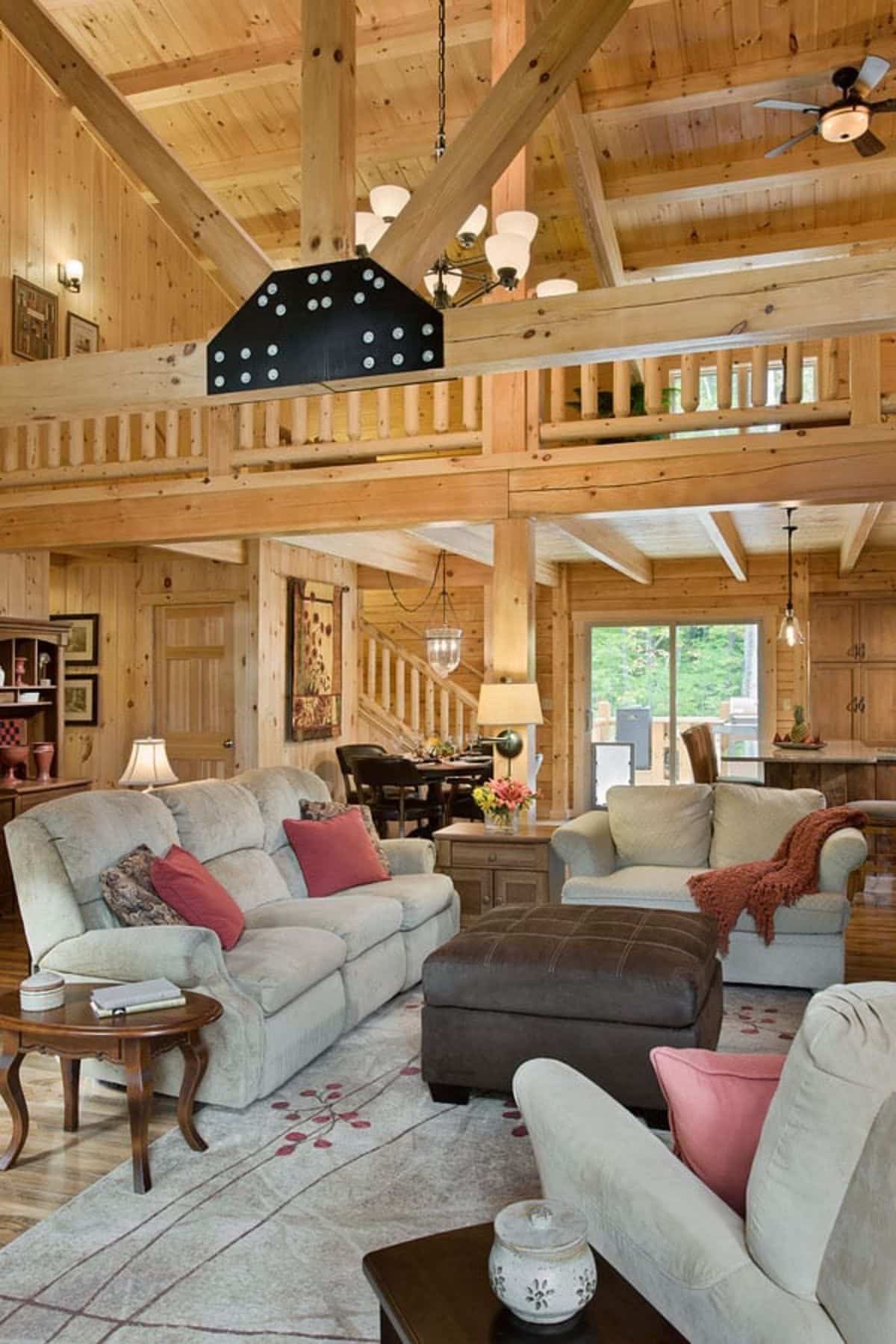 cream sofas with pink pillows in living room below lof landing