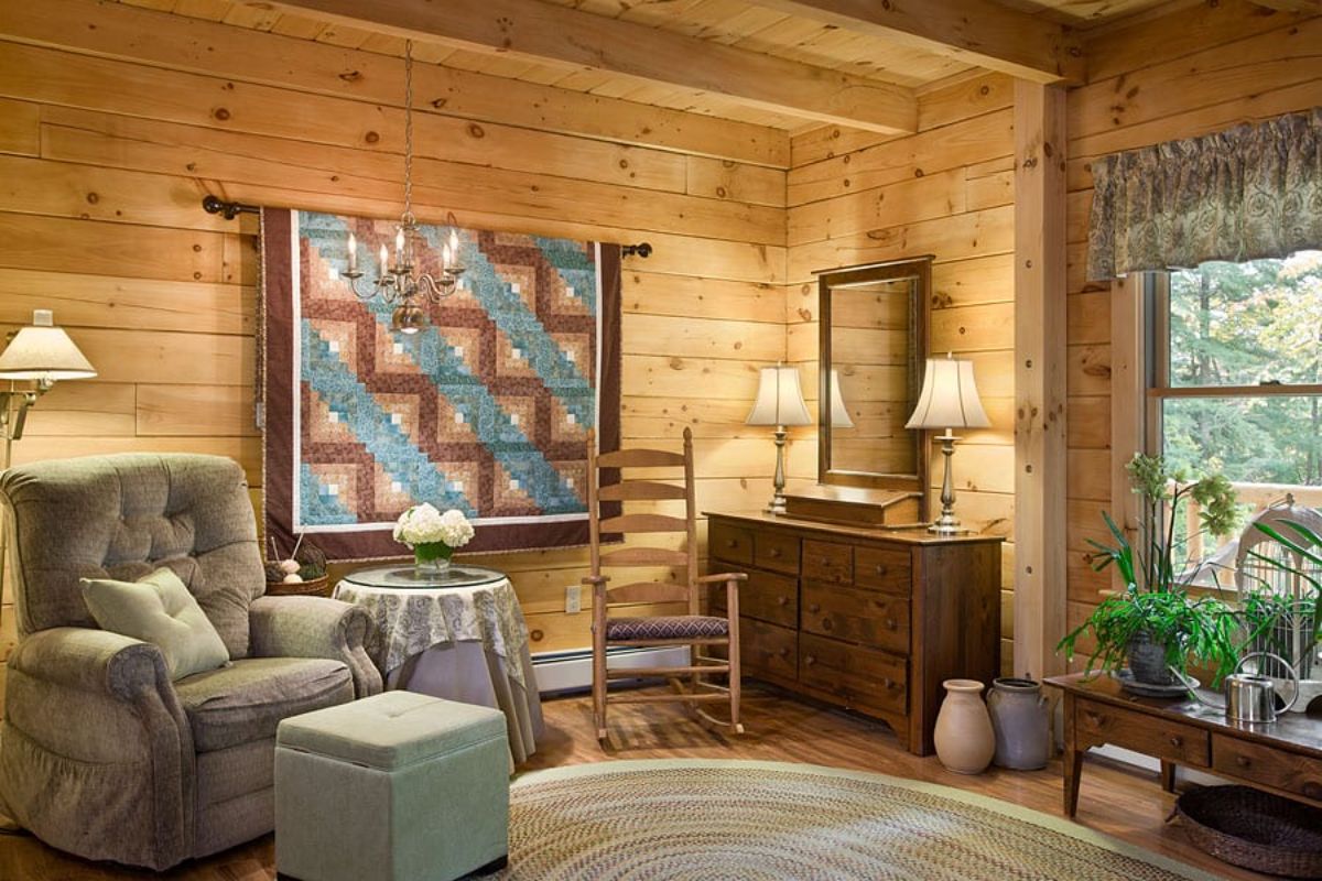 bedroom with quilt on wall next to reading chair