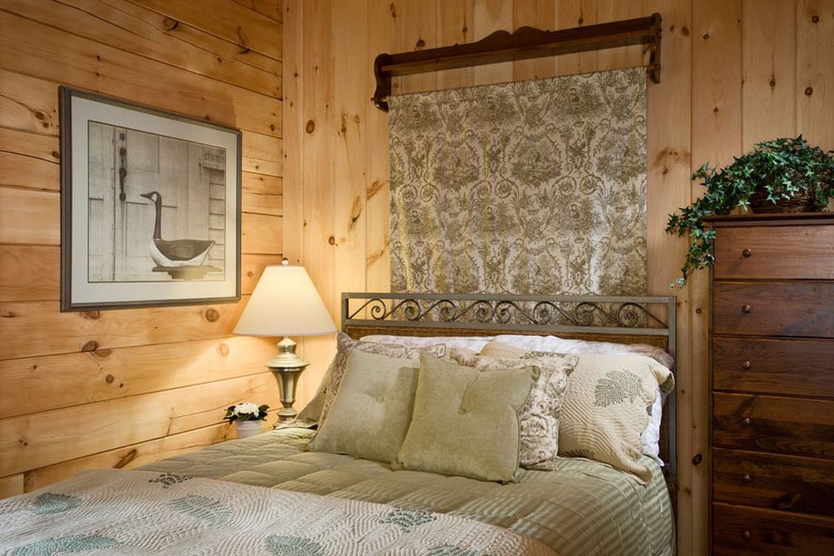 tapestry hanging behind bed in cabin with white linens